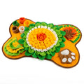 Orange bone shaped snuffle mat for dogs with green fleece petals and a yellow flower centre